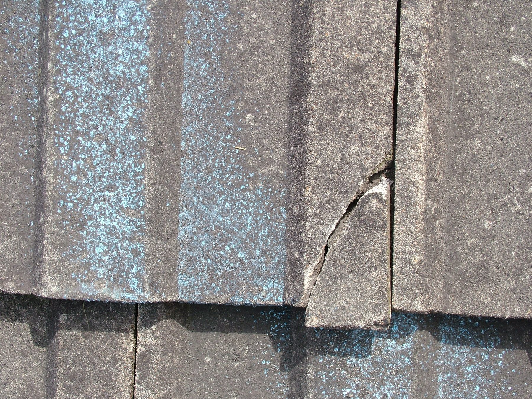 Cracked roof tile close up identified during a roof repair inspection