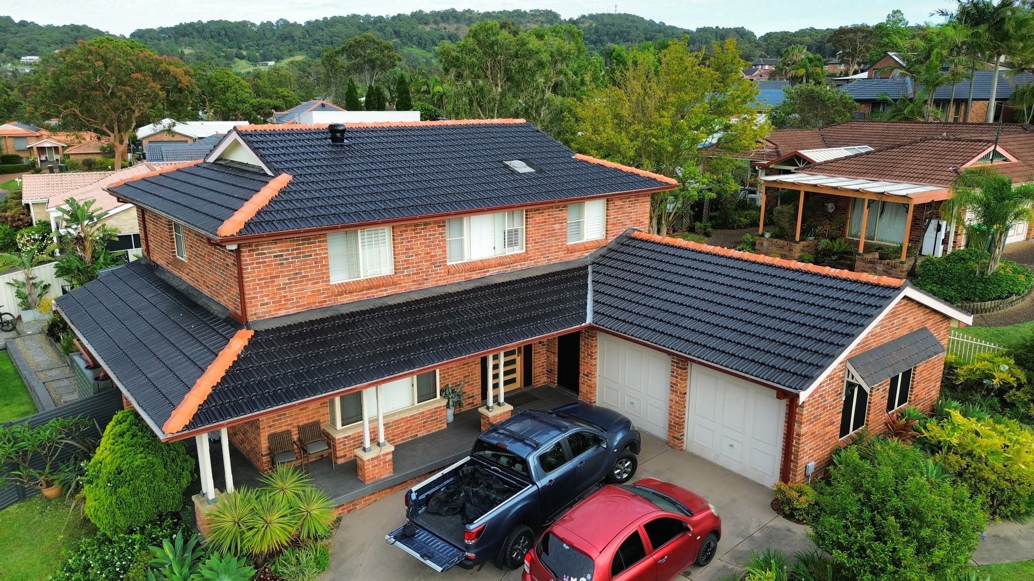 Two-storey brick home with a re-coated roof after insurance roof work