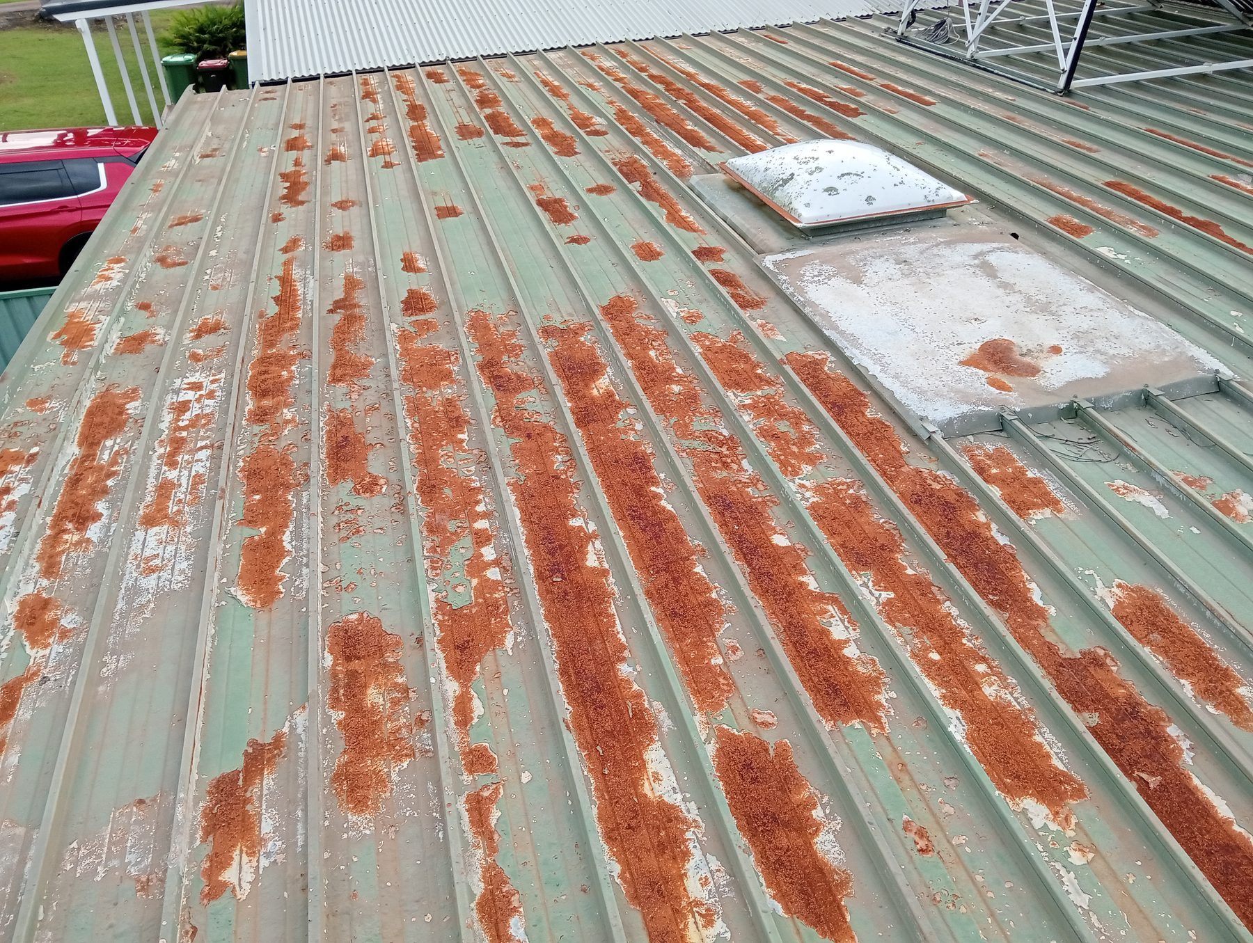 Rusted metal roof sheeting ahead of storm damage and insurance roof work