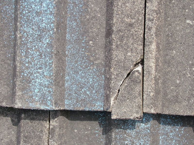 Cracked roof tile identified during a roof leak inspection