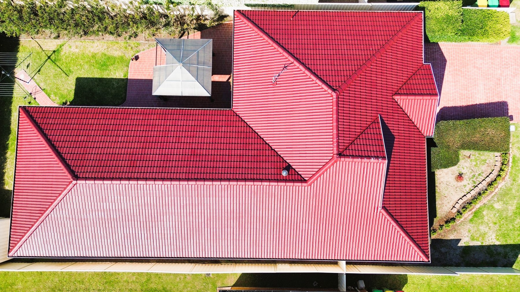 Aerial view of a deep red tile roof after a full roof restoration