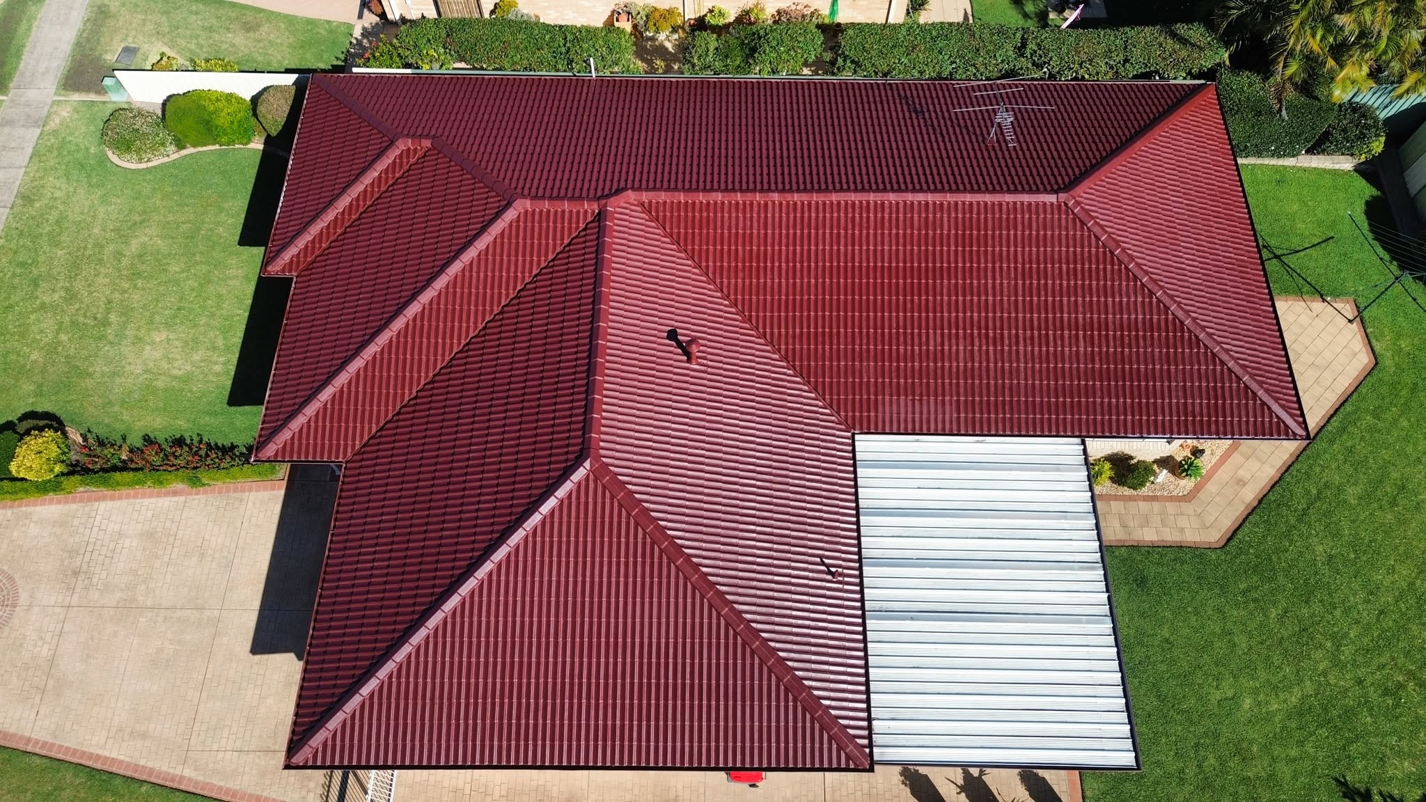 Deep red painted tile roof on a Hunter region home after roof coating