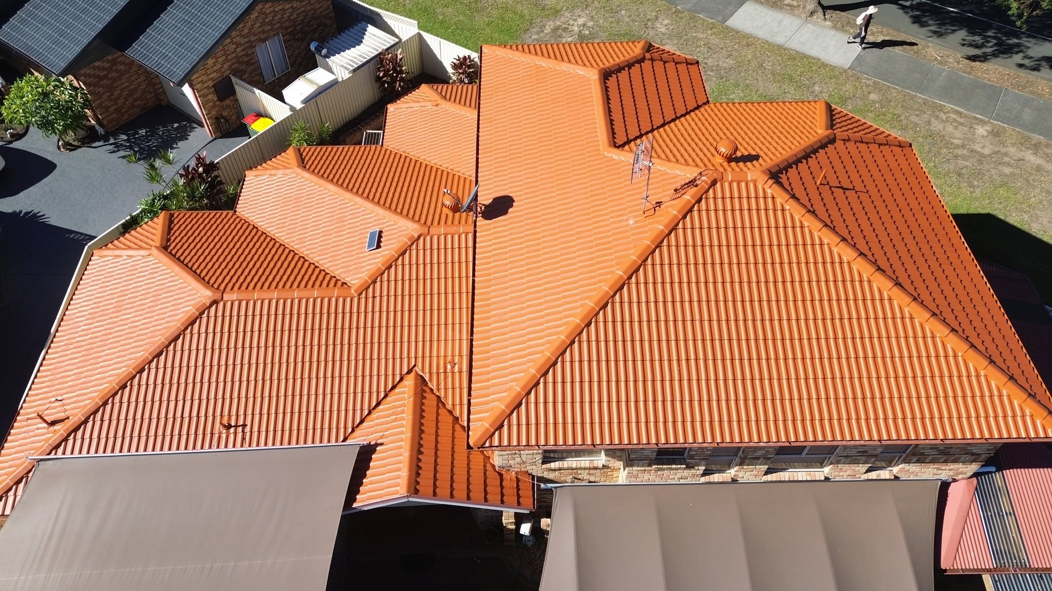Aerial view of a bright orange terracotta roof after roof painting in Newcastle
