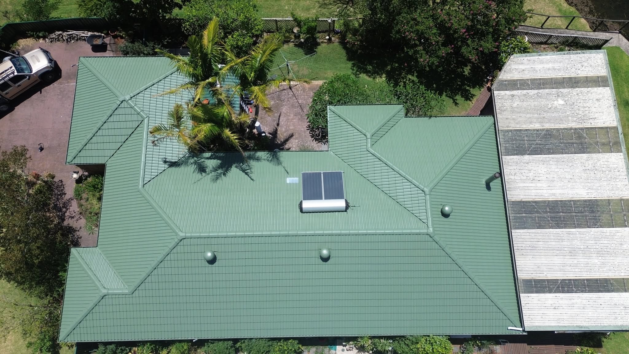Aerial view of a moss-toned roof being cleaned on a Hunter region home